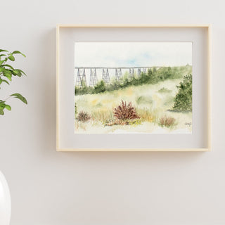 Photo of a watercolor landscape fine art print in a frame. 