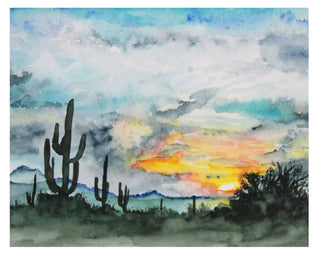 Image of watercolor painting of desert landscape featuring blue and grey clouds with yellow and orange sunset. greyish blue saguaro cactus sillhouettes.